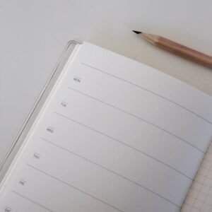 A Brown Pencil Beside a Journal